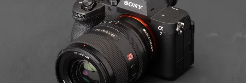 Sony α7 avec objectif G Master sur fond noir, vue 3/4