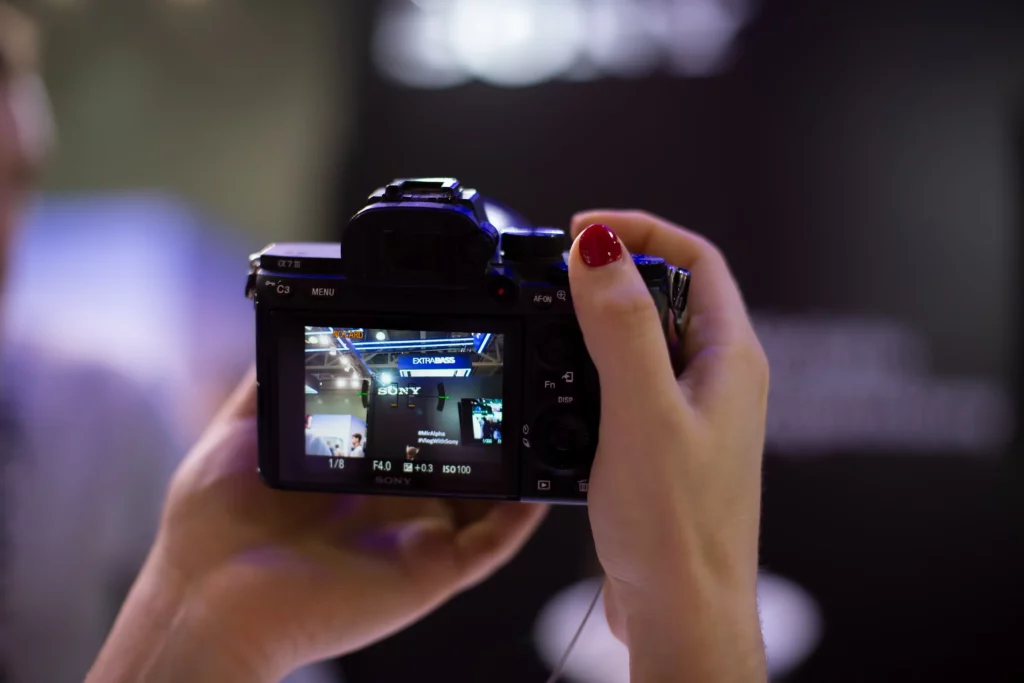 Vue arrière d’un appareil Sony tenu à deux mains, écran LCD affichant la scène