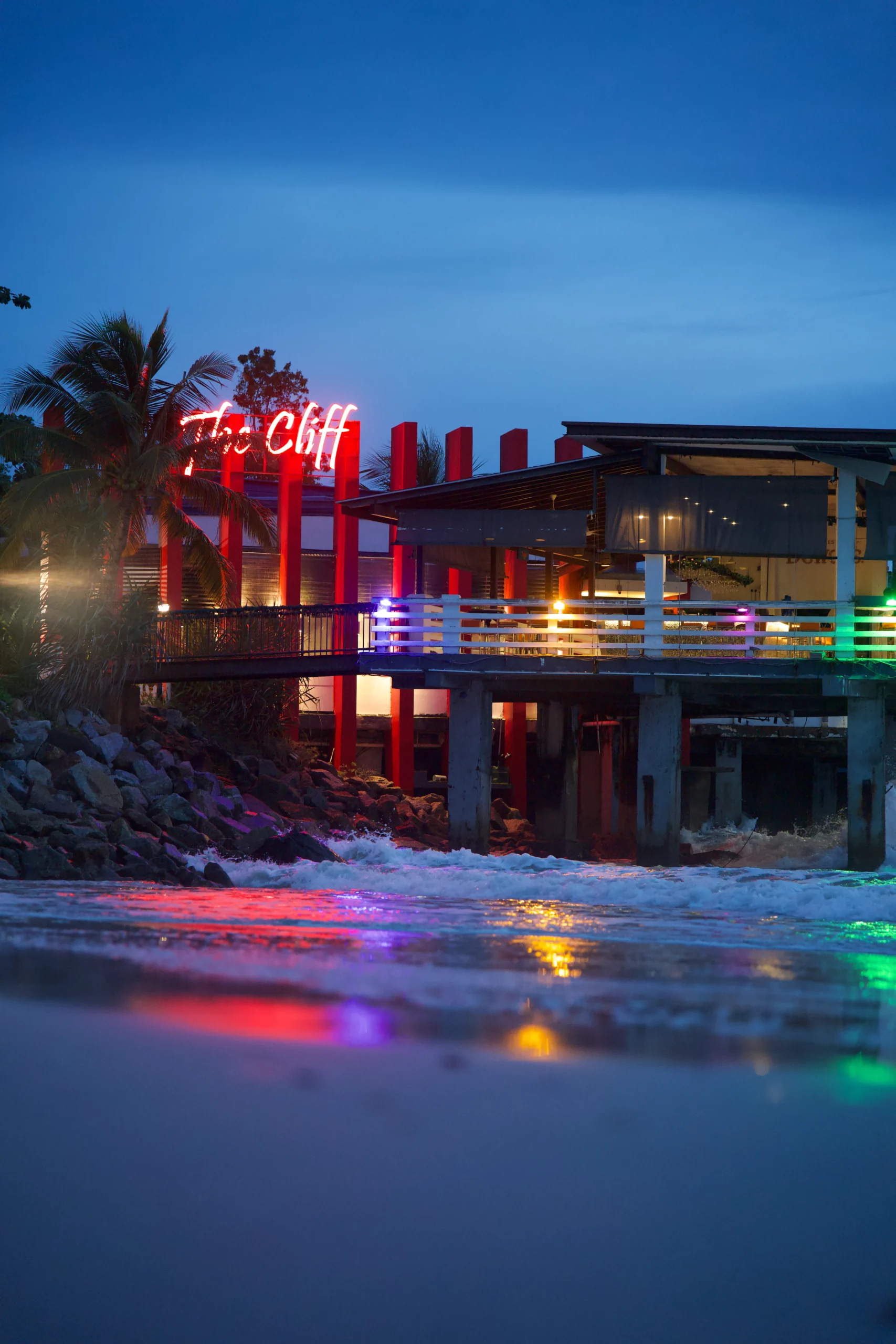 Restaurant The Cliff Langkawi néons rouges pilotis plage vagues nuit, photographie architecture balnéaire exotique Langkawi Malaisie