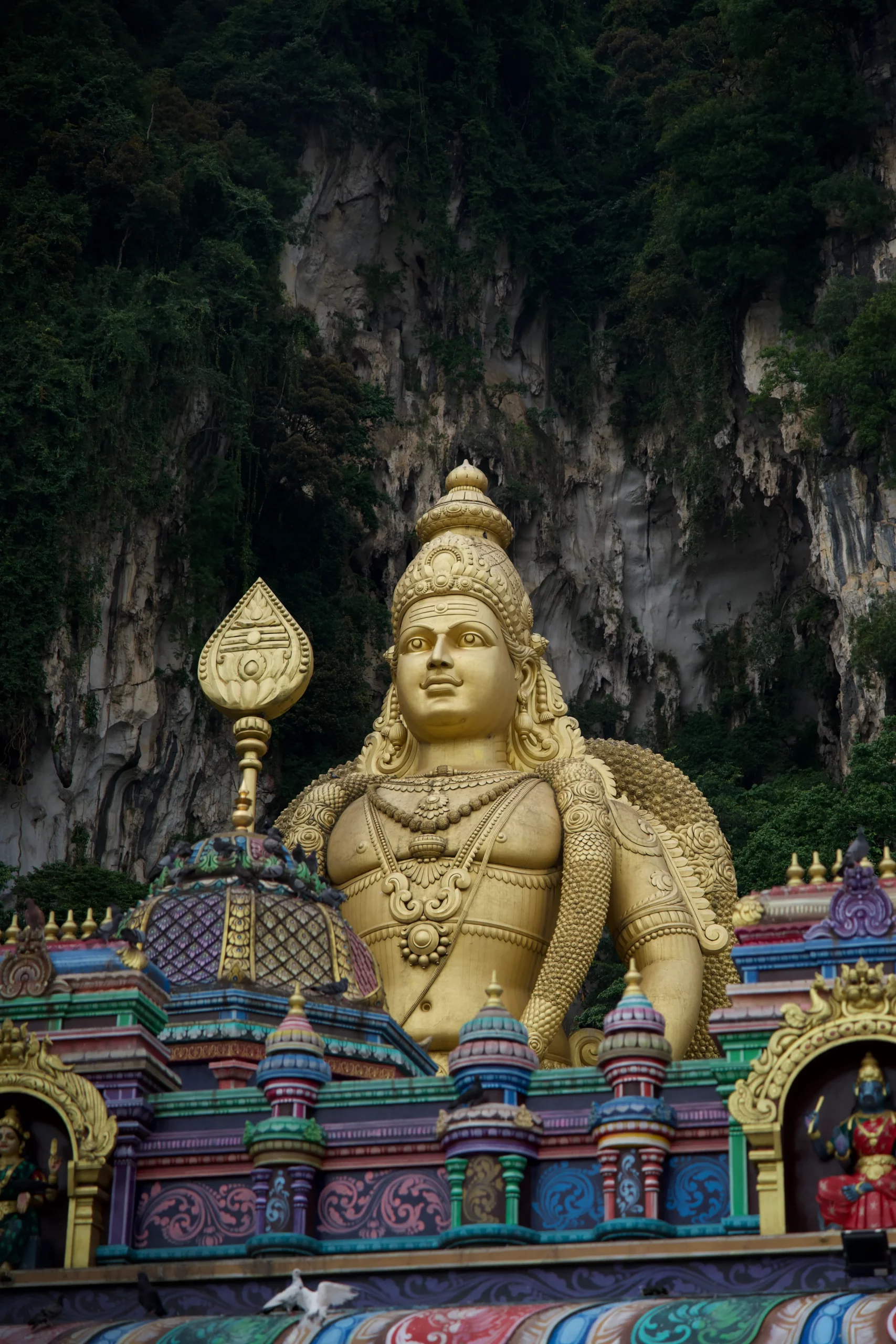 Statues Batu Caves Malaisie Murugan doré escaliers temple hindou jungle, photographie architecture sacrée colorée.