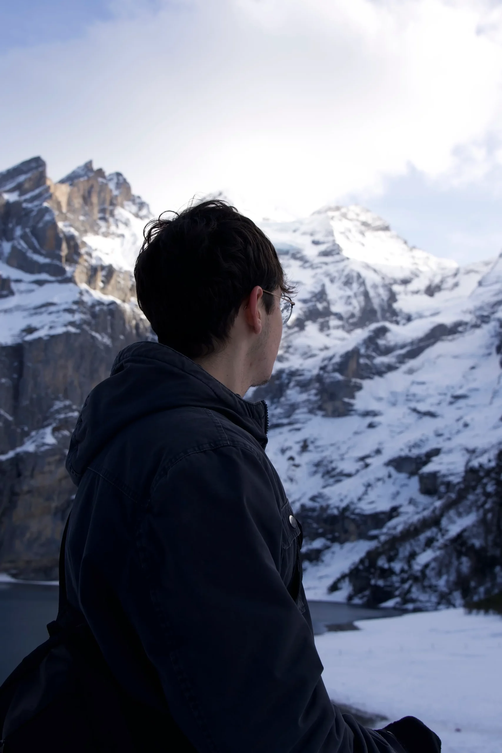 Tatoueur androgyne cheveux blancs lunettes orange gants tattoo studio sombre, photographie portrait artistique intense.